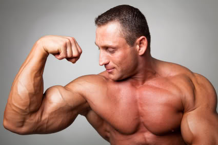 Muscular man flexing his biceps on gray background