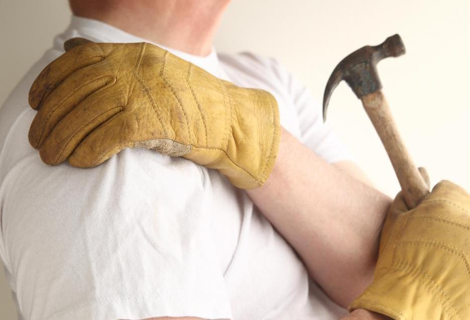 man-in-gloves-grasping-shoulder-in-pain-with-hammer